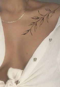 a woman wearing a white shirt with tattoos on her chest