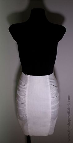 a mannequin with a black top and white skirt on it's back