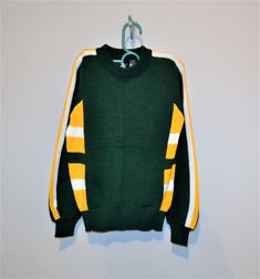 Vintage boys sweater in excellent, unworn condition. The original tag is on sweater. The shirt is green, gold and white. Great ski, school or Green Bay fan sweater. The gold and white stripes are very retro, 80's. Created for Meijer by Timber Ridge. Non itch acrylic. Measurements: Label size medium Chest-30 inches Length-21 inches fits like size small to medium Thanks-fresh inventory daily: https://www.etsy.com/shop/Christmasvintage Created by: https://www.etsy.com/shop/CheekyVintageCloset Sporty Green Sweater With Ribbed Cuffs, Green Sweater With Ribbed Cuffs For College, Sporty Yellow Sweater For Fall, Sporty Yellow Fall Sweater, Winter College Sweater With School Spirit, Green Sporty Crew Neck Sweater, Green Fall Sports Sweater, Sporty Yellow Crew Neck Sweater, Sporty Winter School Sweater