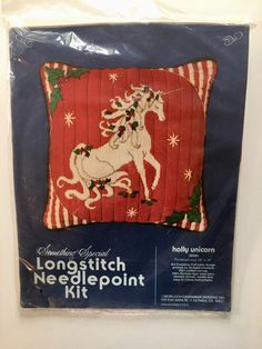 the long stitch needlepoint kit features an image of a unicorn on a red background