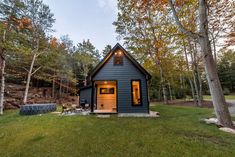 a small cabin in the woods with lights on