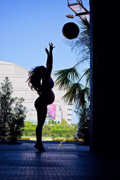 a woman is playing with a basketball outside