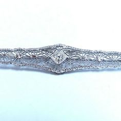 .15ct. Diamonds Filigree Brooch Pin. Rounds, Full Cut Brilliant. I-Color Vs-2 Clarity. 14kt White Gold 4.0 Grams. Overall: 2.5 X .42 Inch Excellent Made Gorgeous Details Ornate Platinum Jewelry, Formal 14k White Gold Filigree Jewelry, Fine Jewelry Platinum Filigree, Ornate White Gold Jewelry With Prong Setting, Formal Cubic Zirconia Jewelry With Filigree Details, Ornate Formal Jewelry With Single Cut Diamonds, Elegant 14k White Gold Jewelry With Rose Cut Diamonds, Formal Cubic Zirconia Jewelry With Filigree, Ornate Brilliant Cut White Gold Jewelry