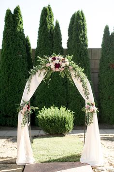 a wedding arch with flowers and greenery