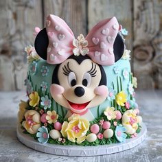 a mickey mouse cake is decorated with flowers