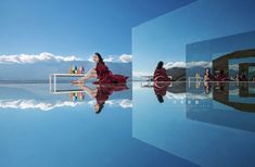 a woman in a red dress is sitting on a bench and looking at the sky