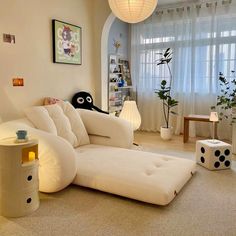 a living room with a large white couch in the center and lots of toys on the floor