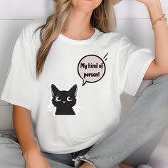 🔰 Are You a Cat Lover at Heart❓ 🎨 Embrace your feline passion with our "My Kind of Person" T-Shirt! This charming tee features a delightful cat design paired with a playful slogan, perfect for expressing your love for all things cat-related. Crafted with care, this shirt offers both style and comfort, making it a must-have for every cat enthusiast. 🎁 Whether you're treating yourself or searching for the perfect gift for a fellow cat lover, this T-Shirt is sure to bring joy and warmth. Ideal f Funny White T-shirt With Cat Design, Funny White Top With Cat Design, Funny White Top With Cat Print, Funny Cat Print Short Sleeve Tops, Funny Cat Print Crew Neck T-shirt, Cute Cat Design, Kind Of, Cat Tshirts Funny, Slogan Tee