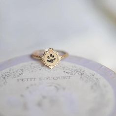 a gold ring with a dog's paw on it sitting on top of a plate