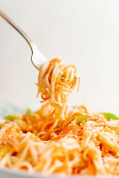 a fork full of noodles is being lifted from the bowl