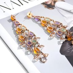 Mesmerizing, Romantic, Distinctive – Introducing the Elegant Crystal Tassel Drop Earrings, a true masterpiece of design and elegance. These long statement earrings feature colourful transparent resin crystals arranged in a stunning tassel structure that lets light shine through, creating a captivating effect. With their glass-like ornaments and elegant length, these earrings are perfect for adding a touch of romance and sophistication to any outfit. Why We Love It... The Elegant Crystal Tassel D Multicolor Crystal Chandelier Drop Earrings, Multicolor Crystal Chandelier Earrings, Elegant Multicolor Drop Tassel Earrings, Elegant Multicolor Dangle Crystal Earrings, Elegant Multicolor Tassel Drop Earrings, Elegant Multicolor Tassel Earrings For Party, Elegant Multicolor Crystal Earrings For Evening, Elegant Multicolor Tassel Earrings For Gift, Elegant Multicolor Tassel Earrings As Gift