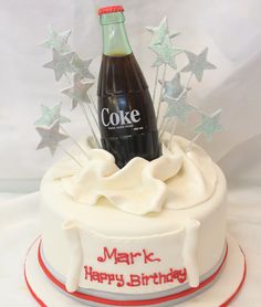 a birthday cake with a bottle of coke on top and stars in the middle for decoration