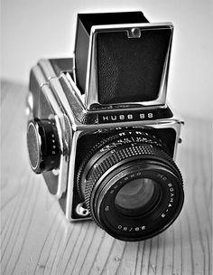 an old camera sitting on top of a wooden table