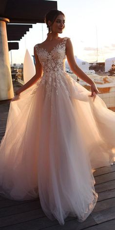 a woman in a wedding dress standing on a dock