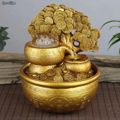 a golden bowl with coins in it and a tree growing out of the top one