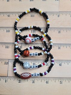 Get your one-of-a-kind, pretty, little thing from Doohickies & Such.  Sign up for the VIP newsletter to get insider news before anyone else! http://eepurl.com/hdVZk9  This is a great gift for the sports mom. Personalize your child's sport team with the sport ball of choice. Each bracelet will say MOM unless you prefer to change. If so, please message me or leave me a note at checkout.  Customize the bracelet to the colors of the team. These would make great fundraising bracelets! Measuring 7.25" and is stretchy, made with double 0.5mm stretch cord.  If you would like a different size than the standard size, please message me or leave a note with your order.  Make sure to leave me a note for the colors you would like your bracelet(s).  Made with love and from a smoke free home. WEAR AND CAR Beaded Sports Bracelets, Personalized Black Sporty Bracelets, Sporty Personalized Black Bracelet, Sporty Personalized Black Bracelets, Black Sports Jewelry With Round Beads, Sporty Adjustable Bracelets For Everyday, Adjustable Sporty Bracelet For Everyday, Customizable Adjustable Sports Bracelet, Adjustable Sports Beaded Bracelets With Letter Beads