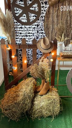 hay bales and hats on display in front of a country themed wallpapered background