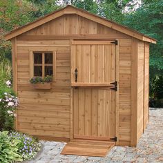 a small wooden shed sitting in the middle of a garden