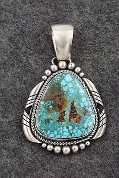 This natural Kingman turquoise and brushed-finish sterling silver pendant was made by Navajo silversmith Paul Livingston. The back is stamped Paul Livingston and sterling.Length: 2 3/4"Width: 1 5/8"Free shipping on all orders! We ship with USPS and always include tracking. All orders ship within a day of payment.Returns are accepted up to 30 days after you receive your order. Just send us a message. Our shop offers cash back or store credit. The item must be returned in new condition. Silver Turquoise Pendant Necklace With Patina, Silver Pendant Turquoise Necklace With Patina, Southwestern Silver Turquoise Necklace With Patina, Collectible Sterling Silver Turquoise Necklace With Patina, Southwestern Untreated Turquoise Collectible Necklace, Sterling Silver Turquoise Necklace With Patina, Untreated Turquoise Pendant Necklace Collectible, Untreated Turquoise Pendant Necklace For Collectors, Bear Carving