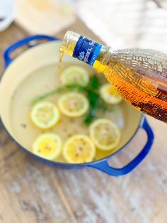 someone pouring syrup into a pan filled with sliced lemons