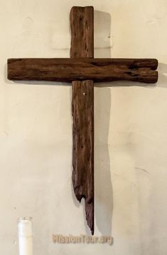 a wooden cross hanging from the side of a wall