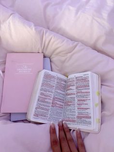 a person is laying in bed with an open book on their lap and reading it