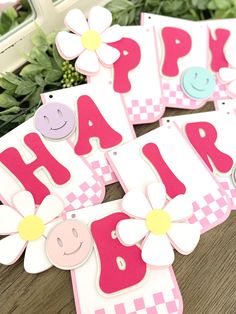 some pink and white cards that say happy birthday with flowers in the middle on a table