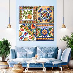 a living room with blue couches and two paintings on the wall above each sofa