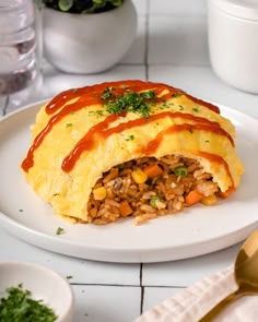 a white plate topped with an omelet covered in meat and veggies