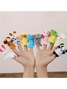 a hand with several small stuffed animals in it