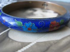 A beautiful antique Chinese Export cobalt blue cloisonne bangle bracelet. As you see, it is decorated in a simple flower and foliage design. The cobalt is real on this bracelet and is a very fine consistency. It is not a cheap imitation sand has almost a translucent quality to it! This bangle is especially nice due to it having a bronze base instead of the common brass base. Measures over 3/8'' wide and 5mm thick. It also measures over 2 1/2'' across the inside and 8 1/2'' along the inside. This Art Deco Locket, Nottingham Lace, Foliage Design, Halloween Bottles, Sewing Lace, Blue Cobalt, Chinese Jewelry, Round Locket, Keys Wedding