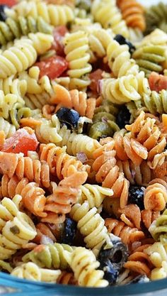 pasta salad with olives and tomatoes in a blue bowl