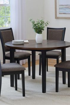 a dining room table with chairs and a vase