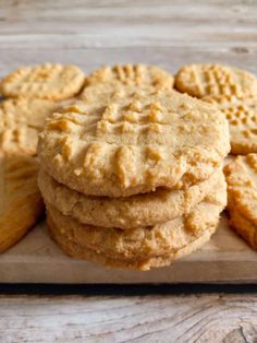 cookies stacked on top of each other on a cutting board next to a glass container