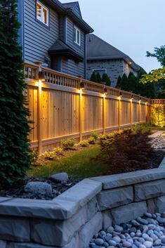 a fence with lights on it next to a house