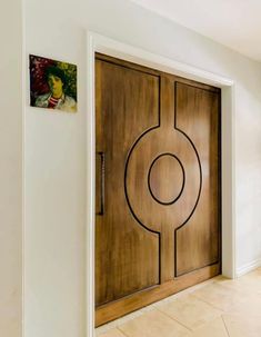 a wooden door with an abstract design on the front and side panels, in a white room