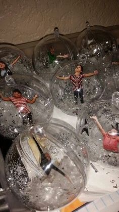 some glass balls with people in them on a table