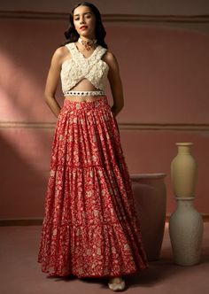 This 3 layered lehenga features intricate chikankari embroidery with badla and sequins. It is paired with an ecru color three-dimensional floral embroidery bustier with mirrorwork belt. The lehenga set shows delicate tassels detail. Red Chikankari Embroidery Sharara For Reception, Bohemian Lehenga With Chikankari Embroidery For Wedding, Bohemian Wedding Lehenga With Chikankari Embroidery, Red Chikankari Embroidery Lehenga For Navratri, Red Lehenga With Chikankari Embroidery For Navratri, Red Lehenga With Chikankari Embroidery For Reception, Fitted Red Lehenga With Chikankari Embroidery, Bohemian Choli With Chikankari Embroidery For Wedding, Red Chikankari Embroidery Choli For Wedding