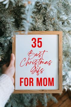 someone holding up a sign that says 35 best christmas gifts for mom on the tree