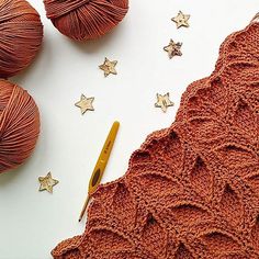 crochet stars next to balls of yarn and a pair of scissors on a white surface