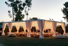 an outdoor wedding reception set up with white draping