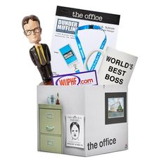 an office cubicle with a cardboard man in the middle and various items on top