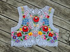 Famous Kalocsa handembroidered vest with authentic Hungarian pattern. High quality hand-embroidered work with lot of work Bust :40 - 41 inch Lenght : 18 " Hand washes only. If you are buying several pieces I can combine postage at the time of mailing. If you have any question please don't hesitate to contact me,  My Etsy shop: https://www.etsy.com/shop/TreasuryCoffer White Floral Embroidery Vest For Spring, Folk Style Embroidered Vest, Bohemian Vest With Multicolor Embroidery For Spring, Bohemian Multicolor Vest With Floral Embroidery, Multicolor Bohemian Vest With Floral Embroidery, Bohemian Multicolor Floral Embroidered Vest, Spring Embroidered White Vest, White Embroidered Spring Vest, White Embroidered Vest For Spring