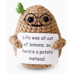 a small crochet character holding a sign that says life was all out of lemons, so here's a potato instead