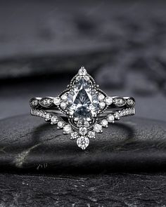 a diamond ring on top of a rock with stones in the foreground and black background