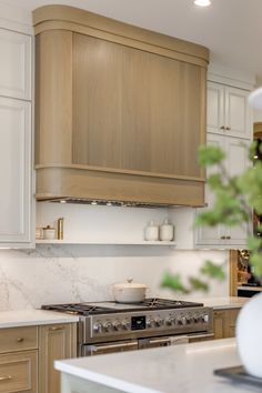 a kitchen with white counter tops and wooden cabinets, along with a stove top oven