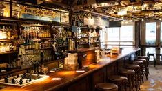 a bar with lots of liquor bottles and stools