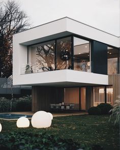 a modern house with large windows and grass