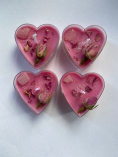 four heart shaped dishes with flowers in them