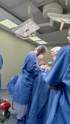 doctors in blue scrubs are performing surgery